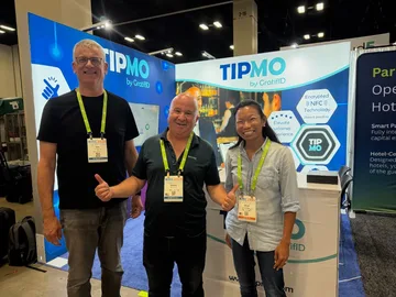 Three GratifID team members smiling at the TIPMO booth during HITEC in San Antonio